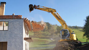 Bagger bringt Mauer zum Sturz