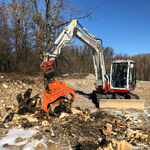 Weißer Bagger mit oranger Spaltzange